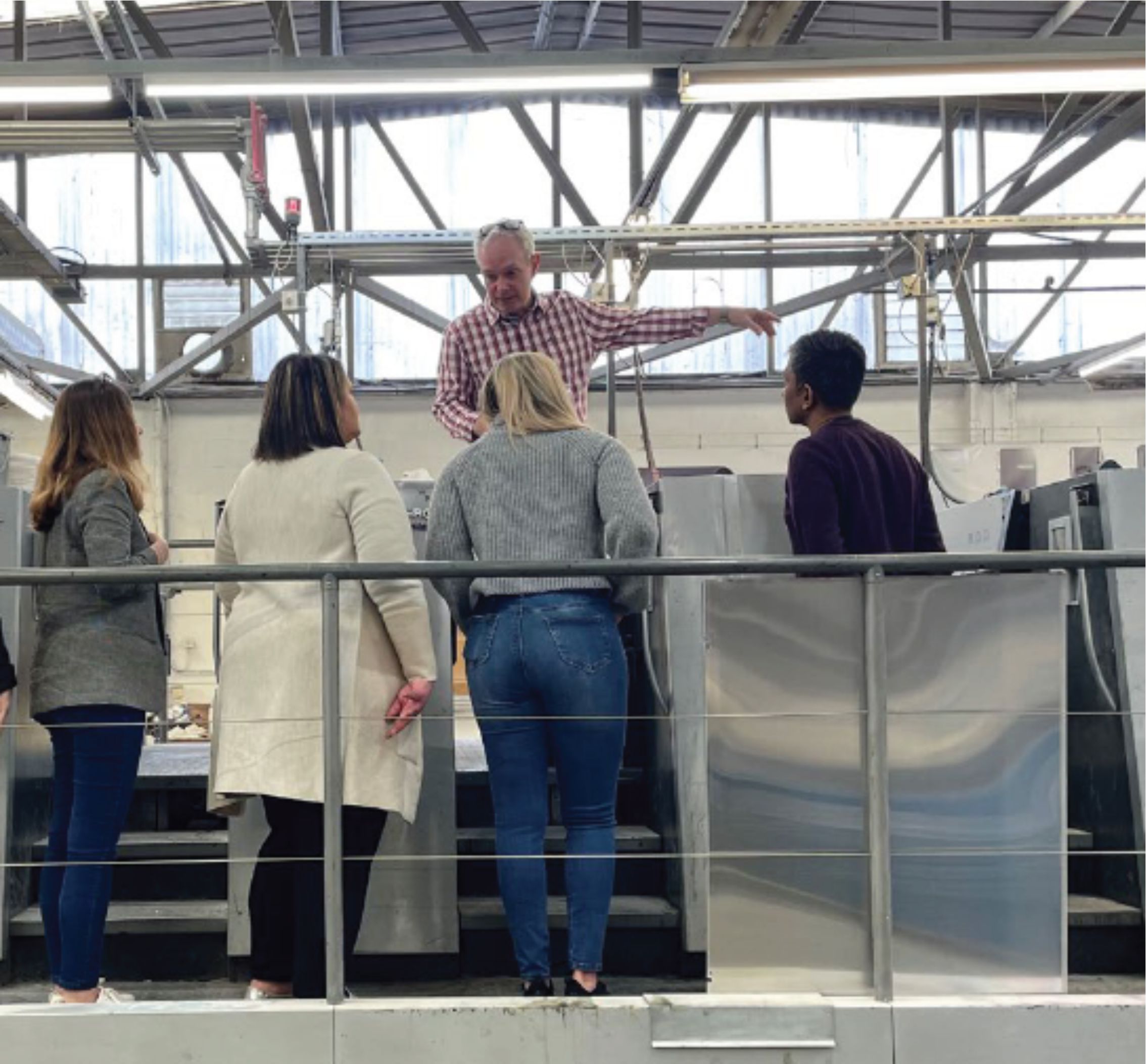 Team facility tour with staff explaining equipment